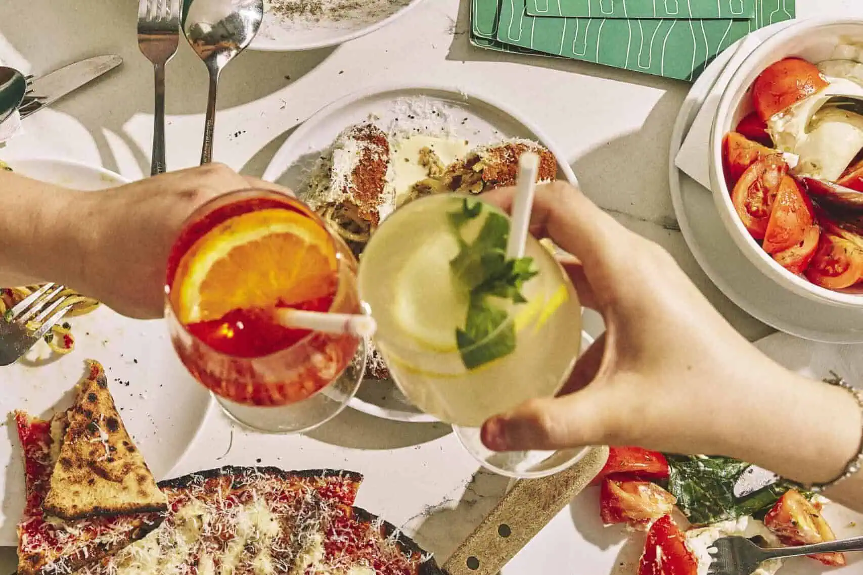Top view of a vibrant Italian feast featuring wood-fired pizzas, burrata, olives, mortadella, and antipasti at 170 Grammi in Sydney