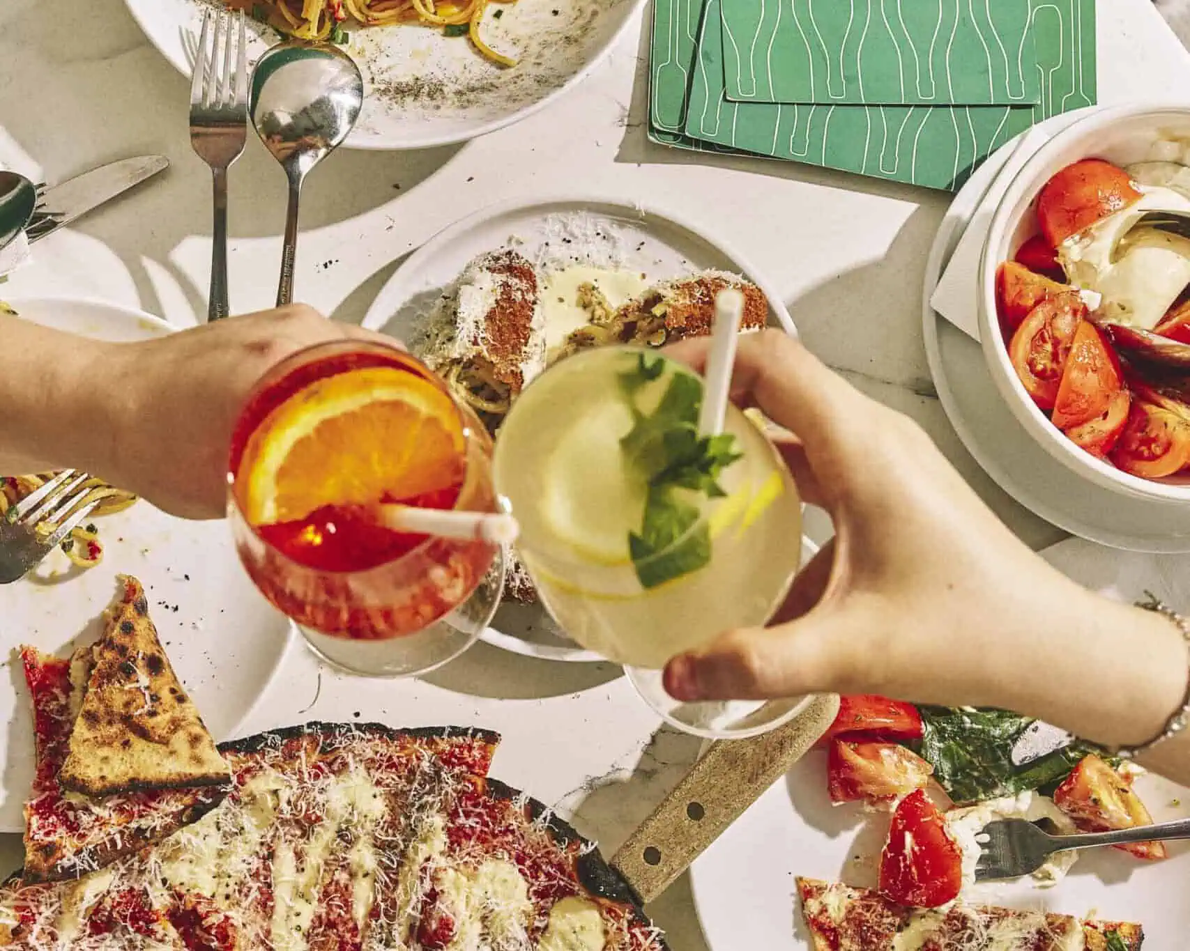 Top view of a vibrant Italian feast featuring wood-fired pizzas, burrata, olives, mortadella, and antipasti at 170 Grammi in Sydney