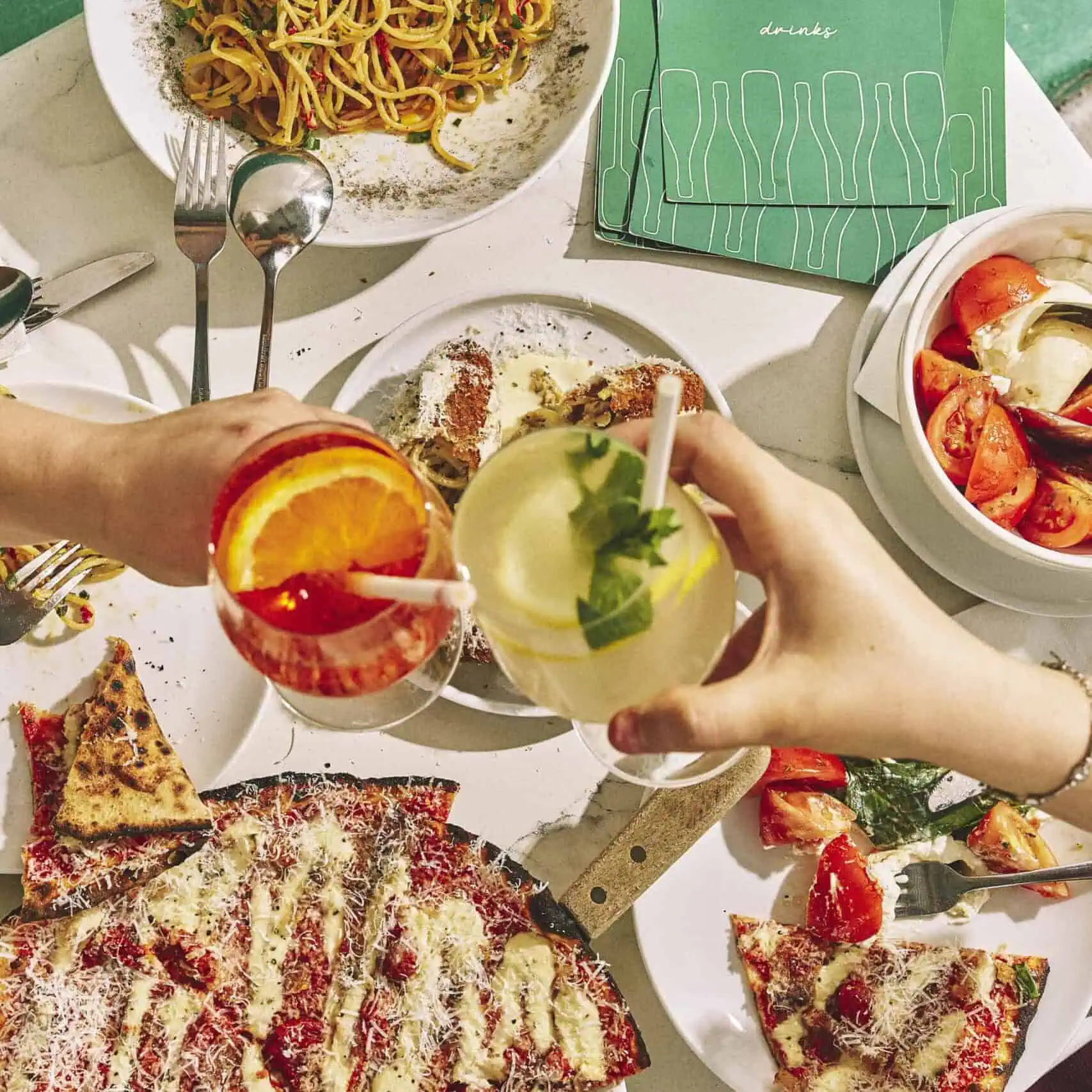 Top view of a vibrant Italian feast featuring wood-fired pizzas, burrata, olives, mortadella, and antipasti at 170 Grammi in Sydney