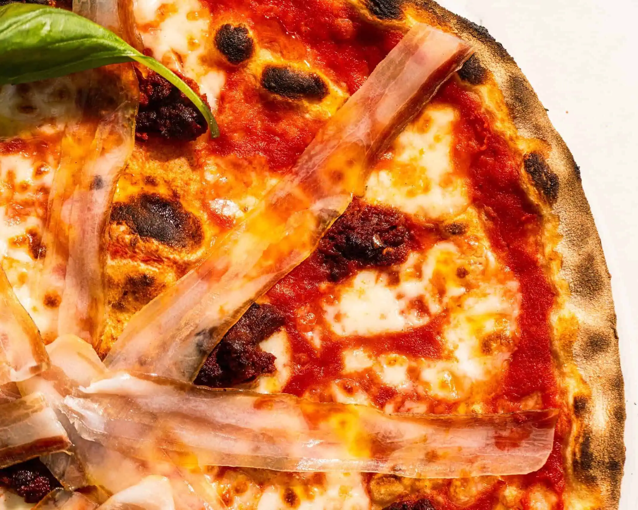 Spicy Calabrese pizza with San Marzano tomato, buffalo mozzarella, ’nduja, pancetta, fresh basil, and Coratina EVOO