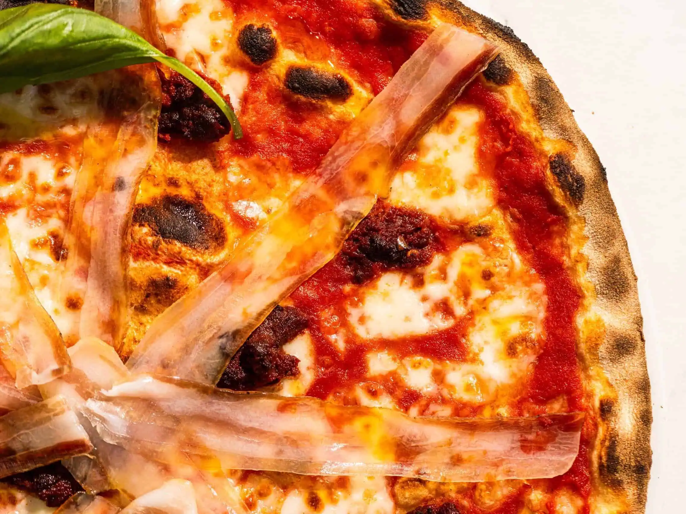 Spicy Calabrese pizza with San Marzano tomato, buffalo mozzarella, ’nduja, pancetta, fresh basil, and Coratina EVOO