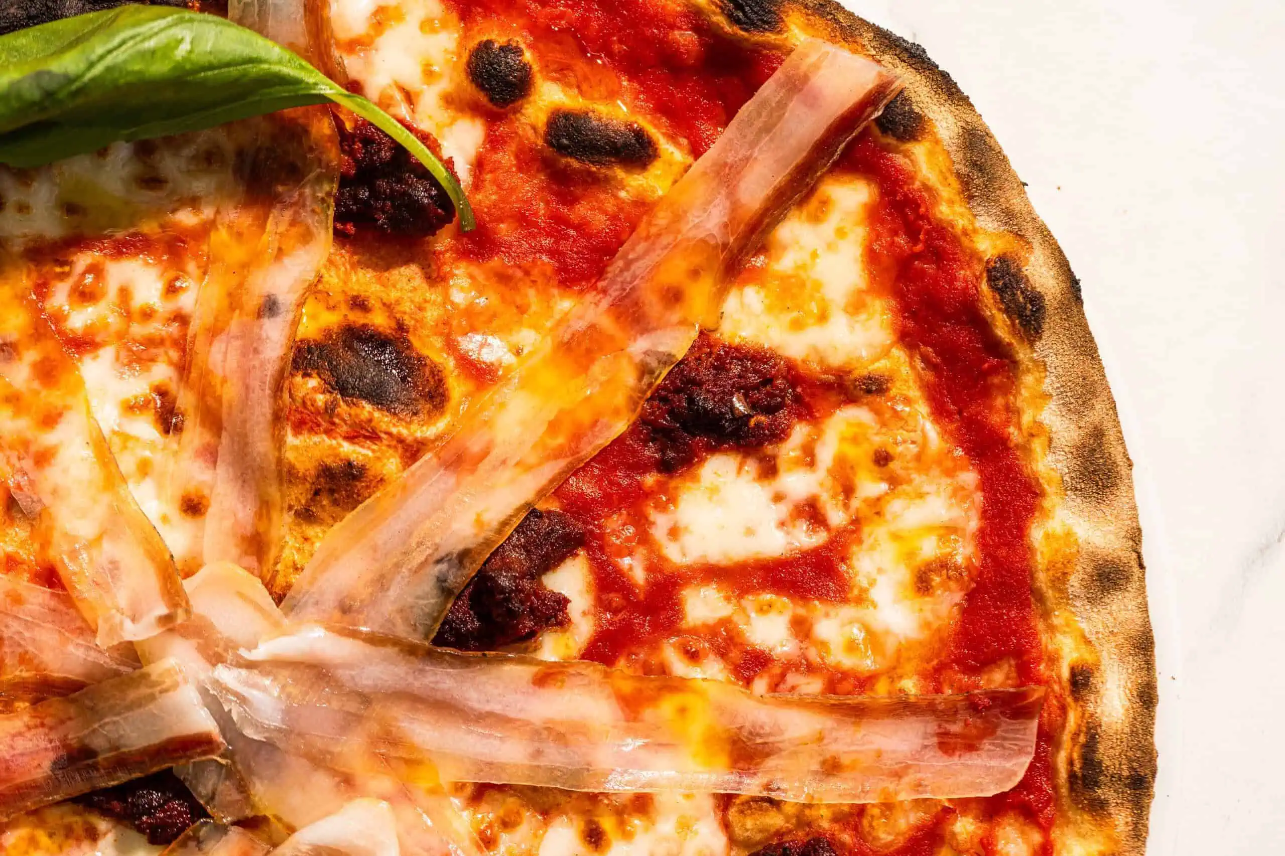 Spicy Calabrese pizza with San Marzano tomato, buffalo mozzarella, ’nduja, pancetta, fresh basil, and Coratina EVOO