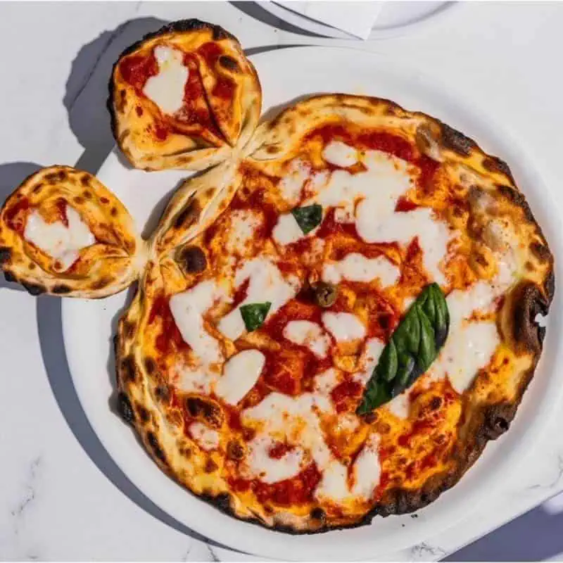 Fun Mickey Mouse-shaped kids pizza with customizable toppings: ham, mushrooms, olives, or salame – perfect for little diners