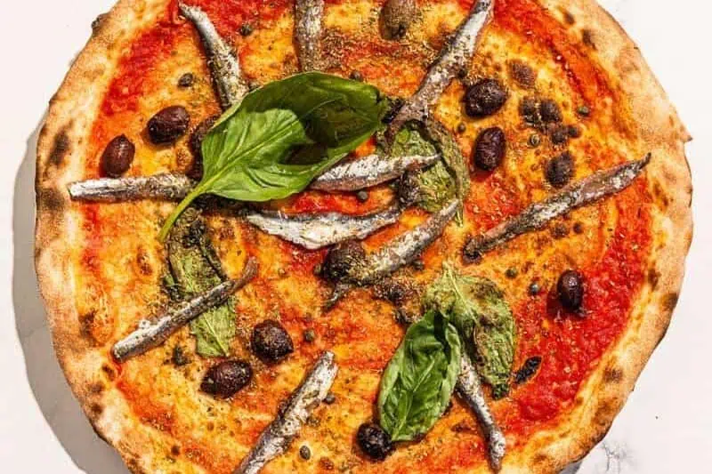Traditional Napoletana pizza with San Marzano tomato, Cetara anchovies, Sicilian capers, Gaeta black olives, basil, and Coratina EVOO &ndash; no cheese