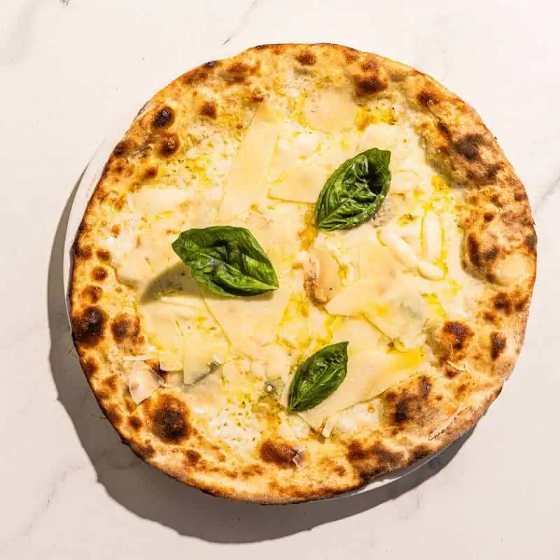 Four cheese Italian pizza with a white base, topped with La Stella buffalo mozzarella, Gorgonzola Dolce, Scamorza, and Taleggio