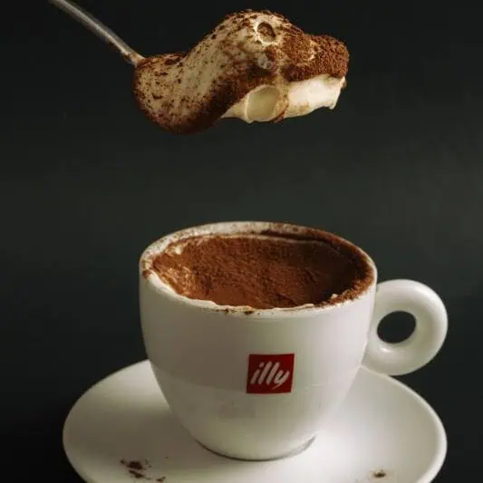 Traditional tiramisù with layers of espresso-soaked ladyfingers and smooth mascarpone cream, dusted with rich cocoa powder