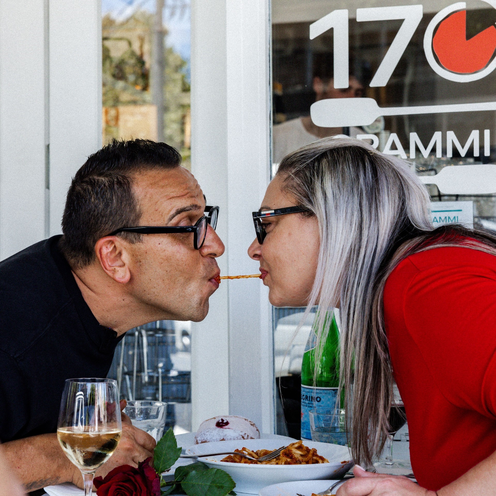 Luigi and Sonia Esposito sharing a pasta strand at 170 Grammi Pizzeria